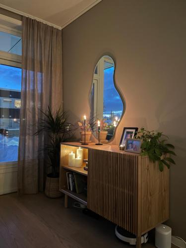 a room with a mirror and a table with candles at Cosy and centrally located apartment in Tromsø