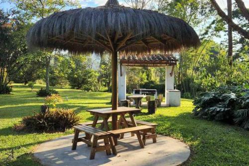 una mesa de picnic y una sombrilla en un parque en Beautiful Country House located in Llanogrande en Rionegro