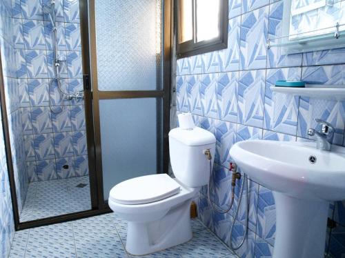 a bathroom with a toilet and a sink at Apparts meublés Tigson in Yaoundé