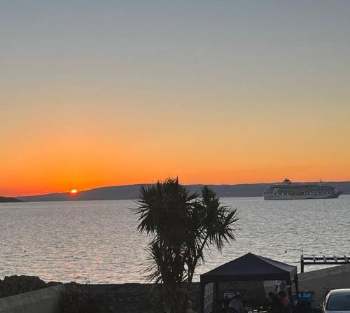 a cruise ship in the water at sunset at Luxurious Seaside Apartment in Bangor