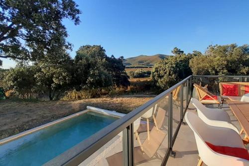 d'un balcon avec une piscine, une table et des chaises. dans l'établissement Villa Rossa Contemporaine Piscine chauffée, à Palasca