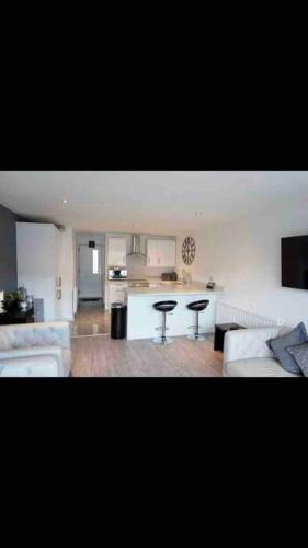 a living room with a couch and a kitchen at Luxurious Seaside Apartment in Bangor