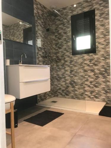 une salle de bain avec un lavabo et une douche dans l'établissement Villa Rossa Contemporaine Piscine chauffée, à Palasca