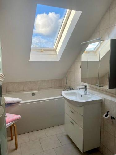 a bathroom with a window and a tub and a sink at Schöne Ferienwohnung im Grünen in Hainichen