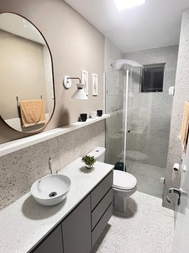 een badkamer met een wastafel, een toilet en een spiegel bij Apartamento prox shopping atlântico BrisamarBC5 in Balneário Camboriú
