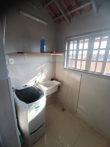a small bathroom with a sink and a toilet at Jardim das orquideas 2 in Rio das Ostras