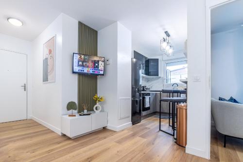 a living room with a kitchen and a dining room at Appartement en face gare d'Evry - Proche Paris & Disney - Easy check in - Arrivée autonome -Place de parking privative - Wifi in Évry-les-Châteaux