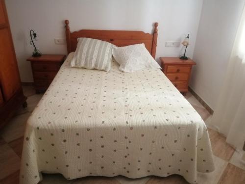 1 dormitorio con cama con edredón y almohadas blancos en EL RINCON DEL MARQUES, en Alcalá de los Gazules