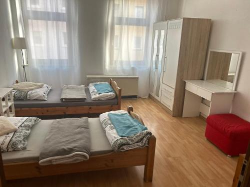 Cette chambre comprend 3 lits et une commode. dans l'établissement Appartement Römerstr 3 Zimer, à Essen