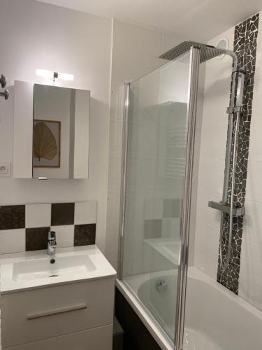 Un baño blanco con lavabo y ducha. en Grand T3- pied des pistes-63 m2-8 personnes, en La Toussuire