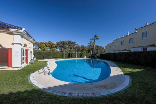 威爾瓦的住宿－Adosado Cigüeñas IV-Islantilla Golf，一座房子的院子内的大型游泳池