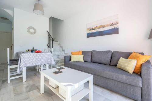 a living room with a couch and a table at Adosado Cigüeñas IV-Islantilla Golf in Huelva