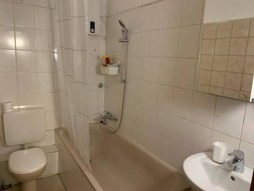 La salle de bains blanche est pourvue de toilettes et d'un lavabo. dans l'établissement Appartement Römerstr 3 Zimer, à Essen