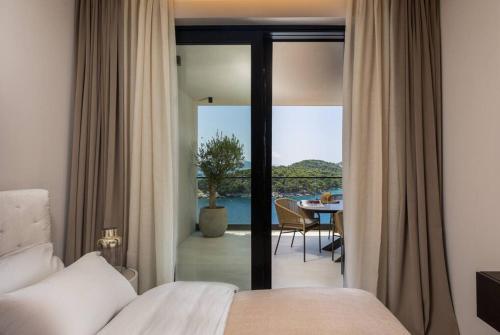 une chambre avec un lit et un balcon avec une table dans l'établissement Luxury Apartment D&D with Sea Access, à Zaton