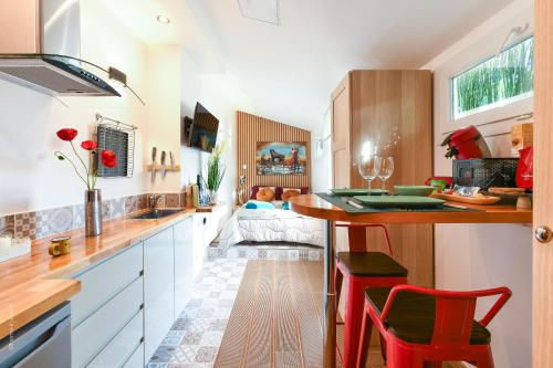 - une cuisine avec un comptoir et des chaises rouges dans l'établissement Paris-Zénith-bienvenue-terrasse-Netflix, à Pantin