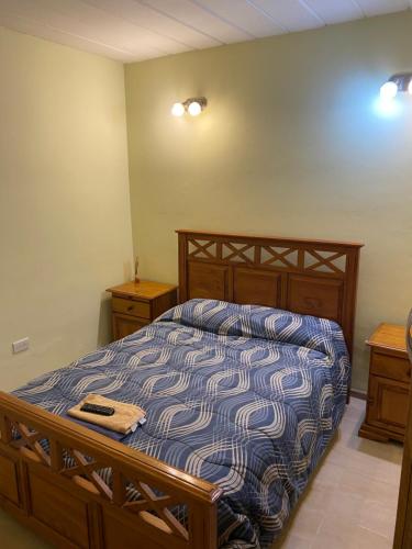 a bedroom with a bed with a blue and white comforter at Dptos RT in Yacimiento Río Turbio