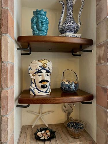 a shelf with vases and a statue on it at Villa Attoni Di Canossa in Anzio