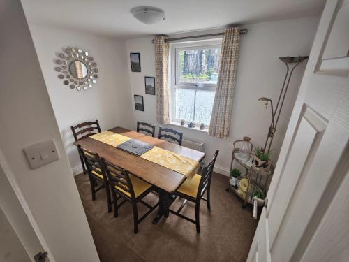 a dining room with a table and chairs and a window at Holme Lea, Ingleton, North Yorkshire in Ingleton 