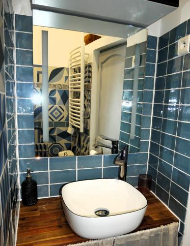 a bathroom with a white sink and blue tiles at L'Oriflamme in Avignon