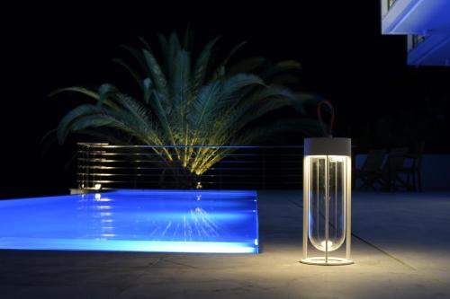 a glass vase sitting in front of a pool at night at Villa Kilada on the Rocks in Kilada