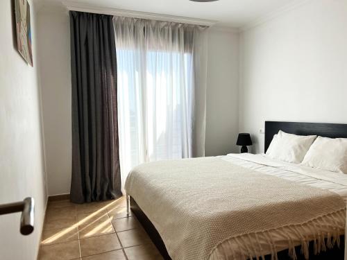 - une chambre avec un lit et une grande fenêtre dans l'établissement Cozy Apartment in La Tejita, à Granadilla de Abona