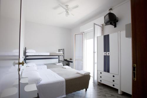 una camera con 2 letti e un ventilatore a soffitto di Hotel B&B Avana a Lido di Savio
