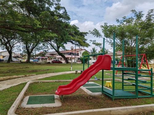 a playground with a red slide in a park at Kuantan Town Staycation 2R2B@HTAA #Netflix in Kuantan