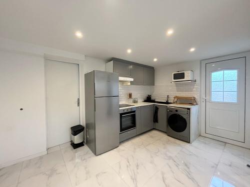 eine Küche mit einem Kühlschrank aus Edelstahl und einem Geschirrspüler in der Unterkunft Maison 2 chambre, CALME a 12 min de La Défense et 20min de Paris in Colombes