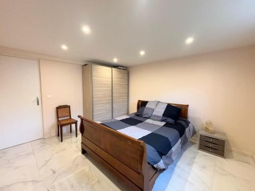 ein Schlafzimmer mit einem Bett und einem Stuhl darin in der Unterkunft Maison 2 chambre, CALME a 12 min de La Défense et 20min de Paris in Colombes