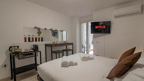 um quarto com uma cama e uma televisão na parede em Lungarno Suite Love [20 minuti da piazza Santa croce] em Florença