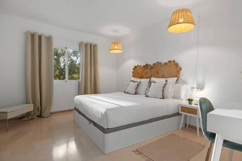 um quarto branco com uma grande cama branca e 2 luzes em Luminoso apartamento en Elviria em Marbella