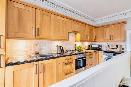 a kitchen with wooden cabinets and a sink at Parkview in Dunkeld
