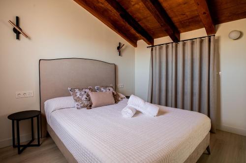 1 dormitorio con 1 cama grande con sábanas blancas en Apartamentos Hartzenbusch, en Teruel