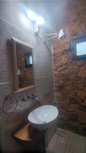 a bathroom with a sink and a mirror on a wall at Cabañas Misioneras in San Ignacio