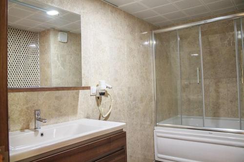 Un baño con bañera, lavabo y ducha. en Hotel Green Valley Savsat, en Savsat