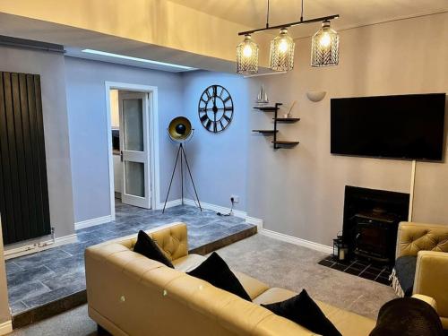 a living room with a couch and a flat screen tv at Cosy Seaside Cottage in Bangor