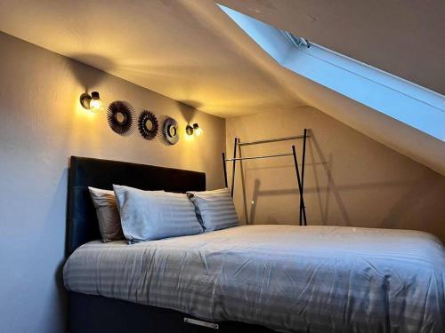 a bedroom with a bed with two clocks on the wall at Cosy Seaside Cottage in Bangor