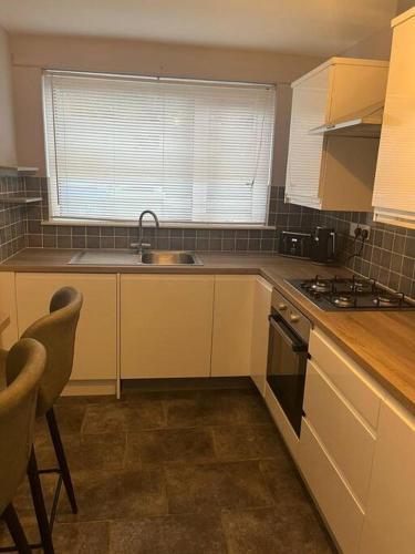 a kitchen with a sink and a stove top oven at Cosy Seaside Cottage in Bangor