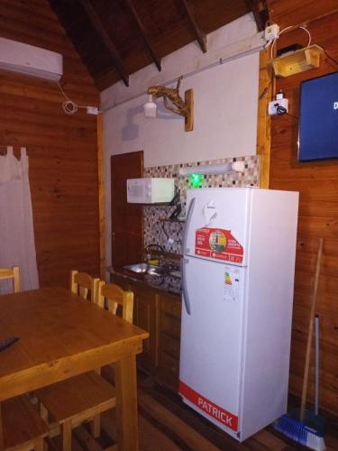 a white refrigerator in a kitchen with a table at Cabañas Misioneras in San Ignacio