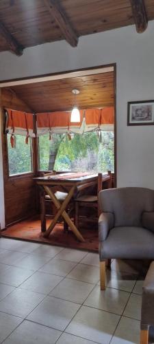 a dining room with a table and a chair at Arroyo Escondido in Trevelin