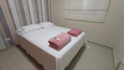 - un petit lit avec un sac rose dans l'établissement Apartamento Alto Padrão próximo Agrishow, à Ribeirão Preto