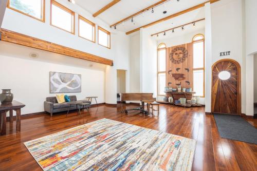sala de estar de planta abierta con piano y mesa en Seaside Art Gallery Loft Inspire Your Creativity with Breathtaking Views!, en Half Moon Bay