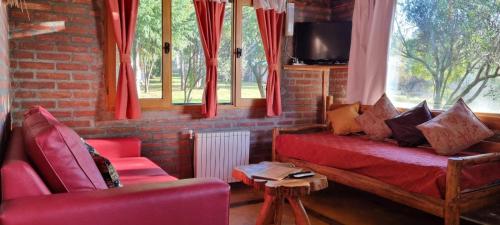 a living room with a red couch and windows at Arroyo Escondido in Trevelin