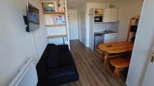 Il comprend une petite cuisine et une salle à manger avec une table et une chaise. dans l'établissement Les aiguilles d'or, à L'Alpe-d'Huez