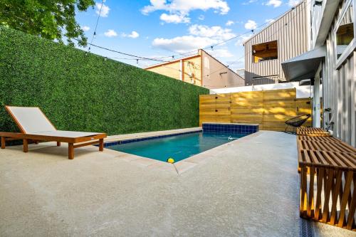 a swimming pool in a backyard with a bench at Ellum House in Dallas