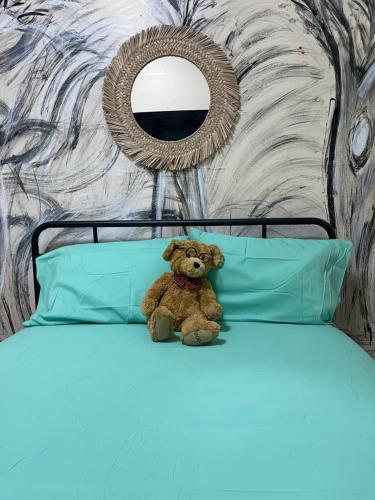 a teddy bear sitting on top of a bed at SUITE Dreams CARROLL 11 in Paterson