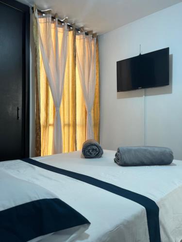 a bedroom with a bed and a flat screen tv at Casa Familiar in Armenia
