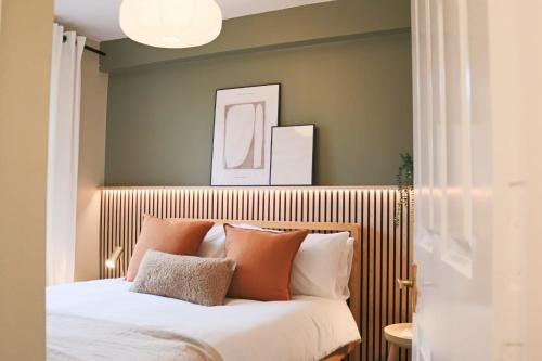 a bedroom with a bed with orange and white pillows at Japandi-Inspired Apt in the Heart of Oxford in Oxford