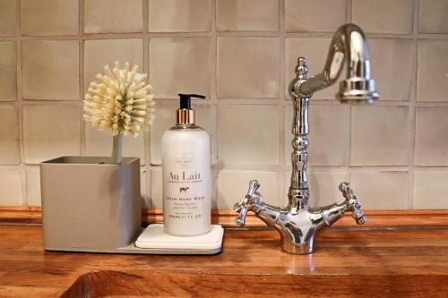 a sink with a bottle of soap next to a faucet at Japandi-Inspired Apt in the Heart of Oxford in Oxford