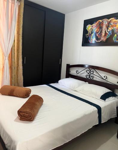 a bedroom with a bed with two pillows on it at Casa Familiar in Armenia